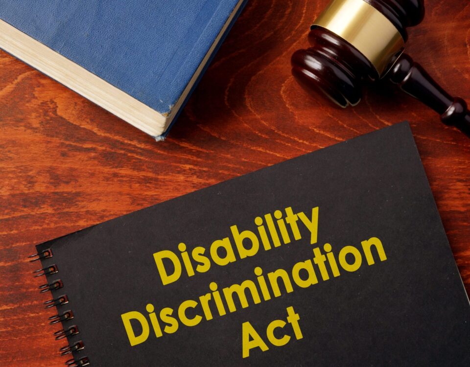 A Disability Discrimination Act (DDA) book with a gavel and a legal text.